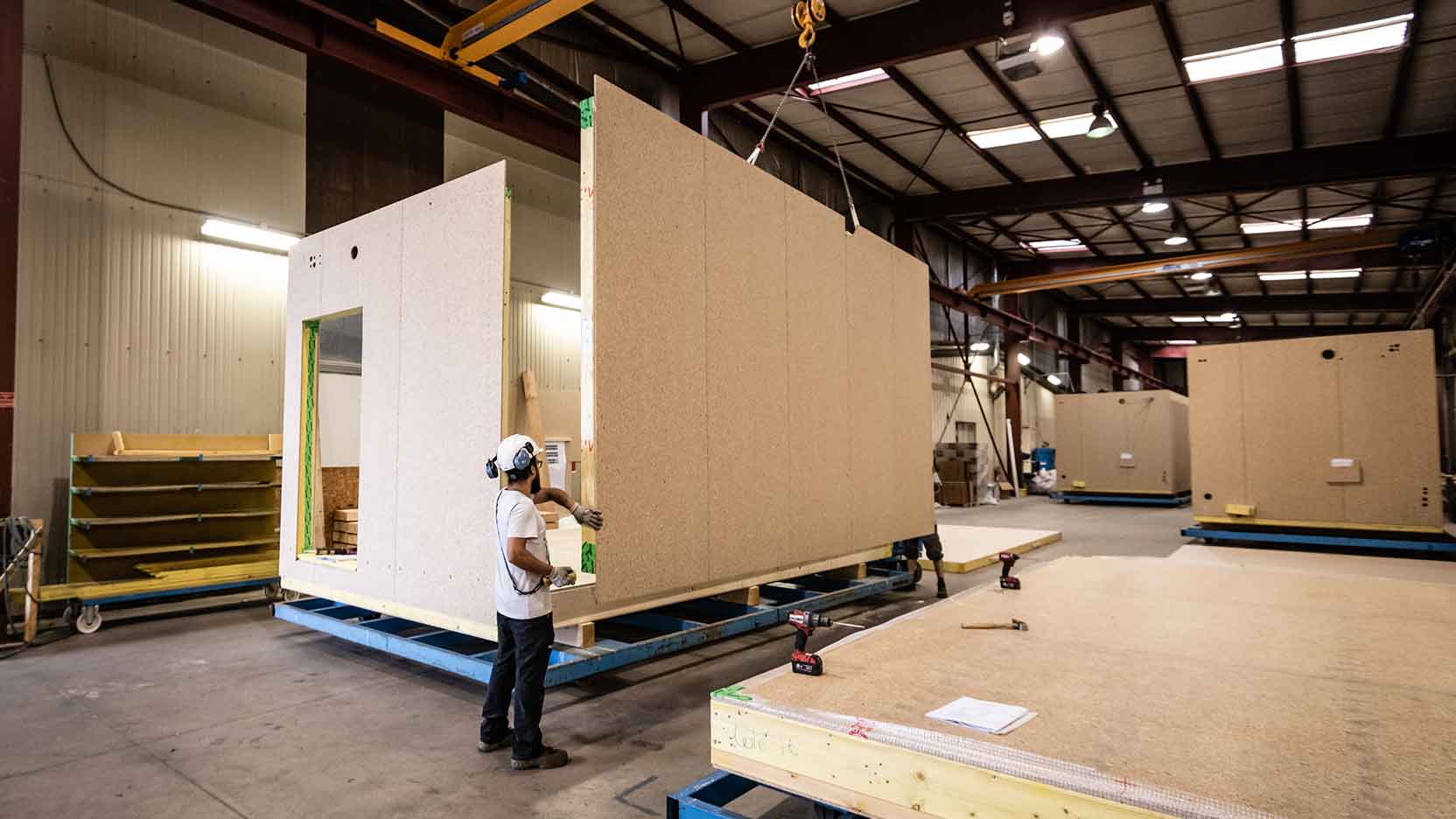 Ossabois, entreprise de construction en France, assemble les murs ossature bois avec le plancher et le toit pour produire des modules 3D.